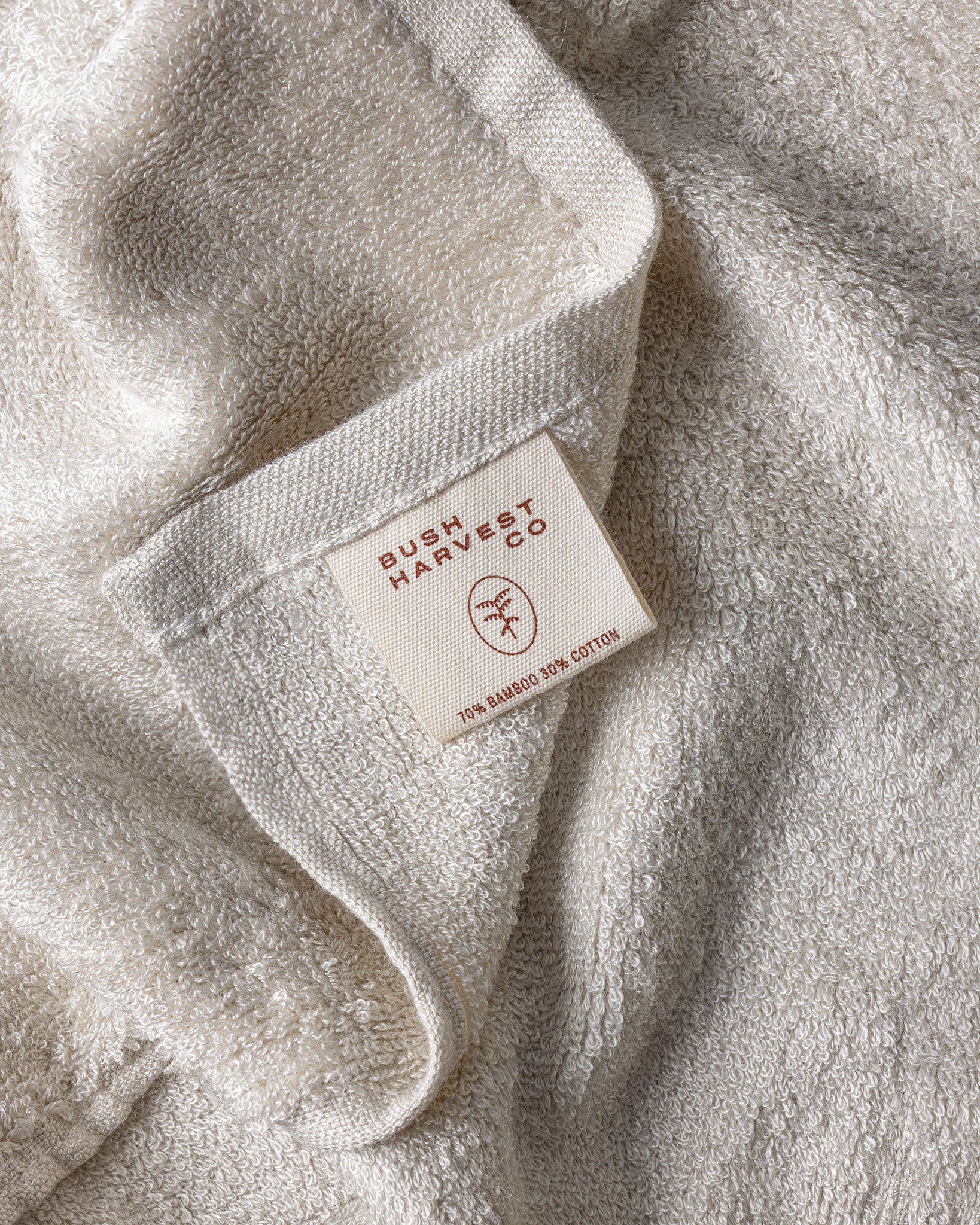 Close up image of reusable, 70% bamboo 30% cotton blend Facial Cleansing Cloth with Bush Harvest Co branded tag.