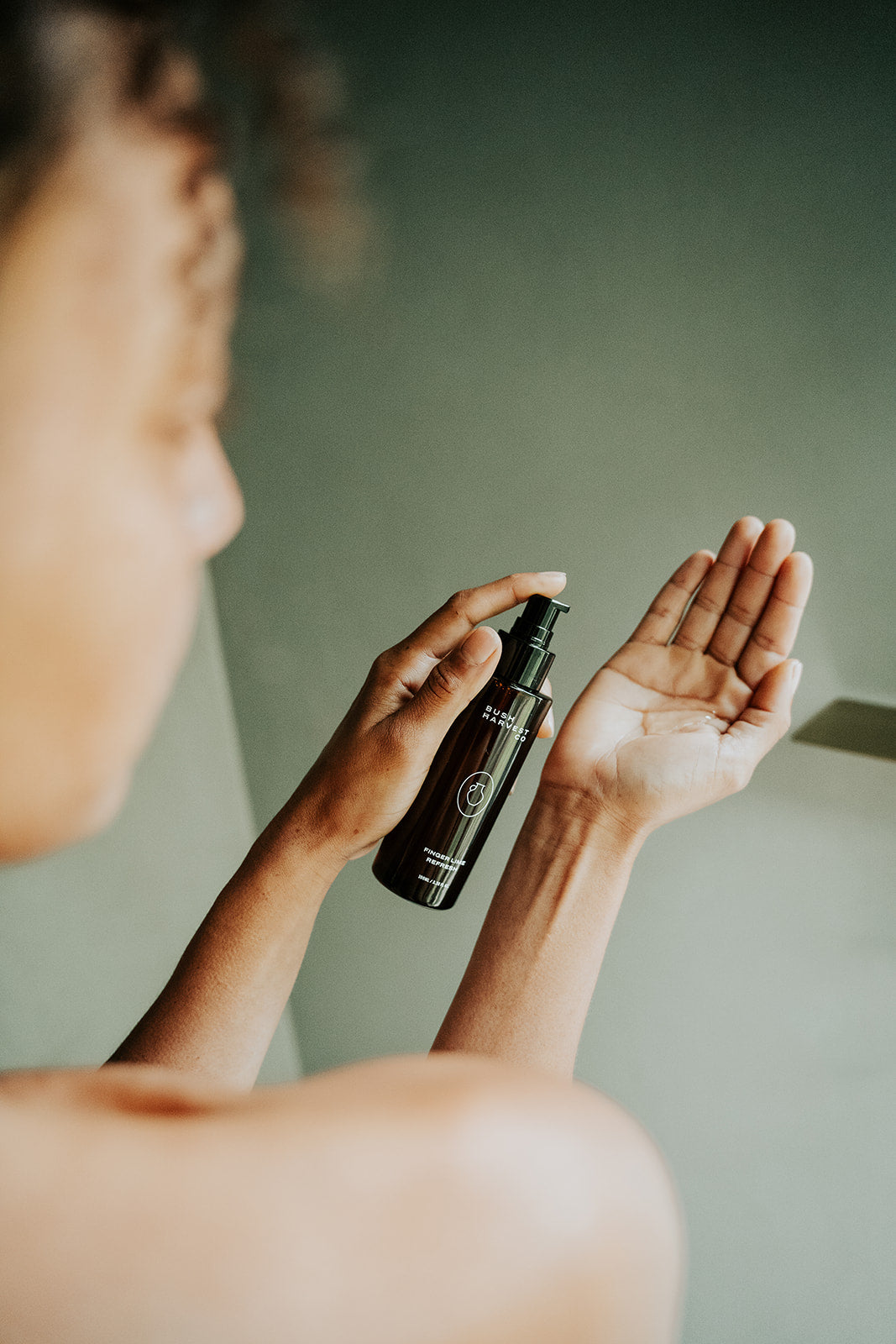 Woman dispensing Finger Lime Refresh Purifying Facial Cleanser into hand.
